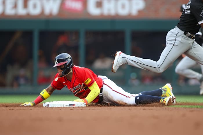 Ronald Acuña Jr. slides into a base underneath a White Sox players’ leg